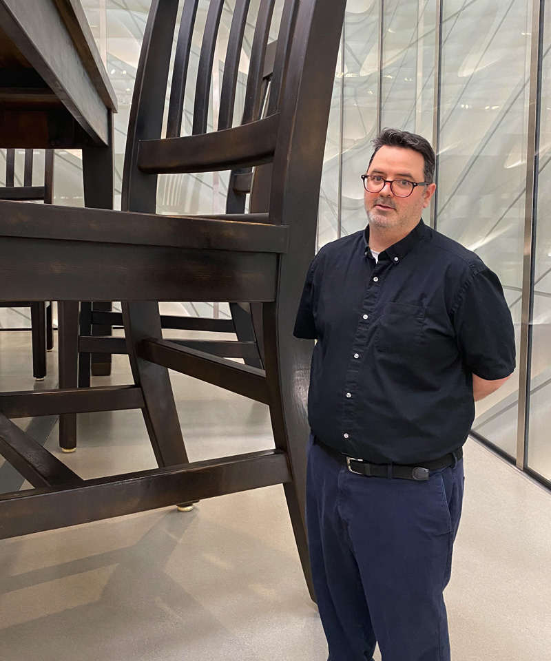Craig Jessen standing beside an oversized chair